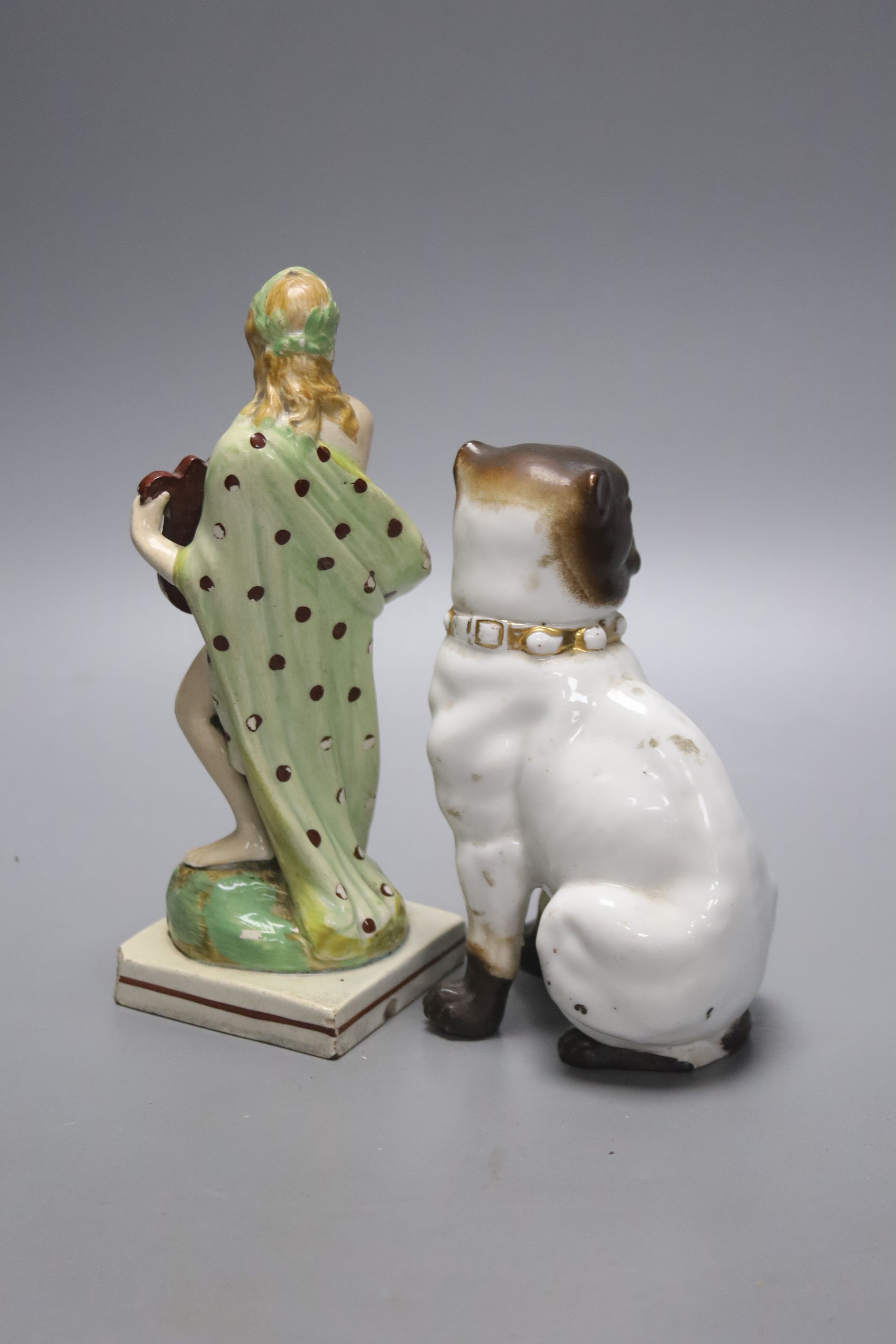 A pearlware figure of a lady, c.1800, with a harp together with a German porcelain figure of a pug (2), tallest 18.5cm
